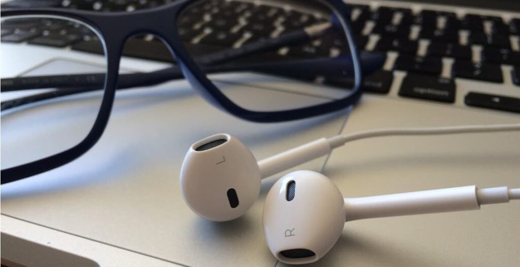 a pair of white earphones on a keyboard